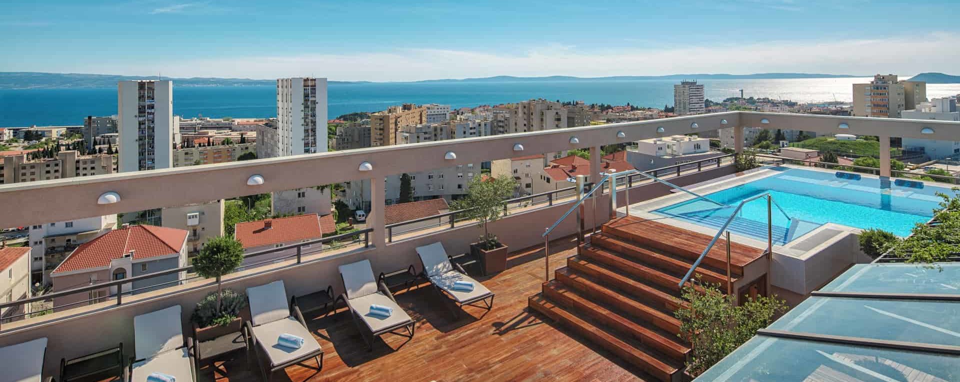 The rooftop terrace, sundeck in the Dioklecijan Hotel & Residence Split Croatia, pool and pool furniture with olive trees and plants, relaxing area, panoramic view on Split Croatia, Adriatic sea and Dalmatian islands
