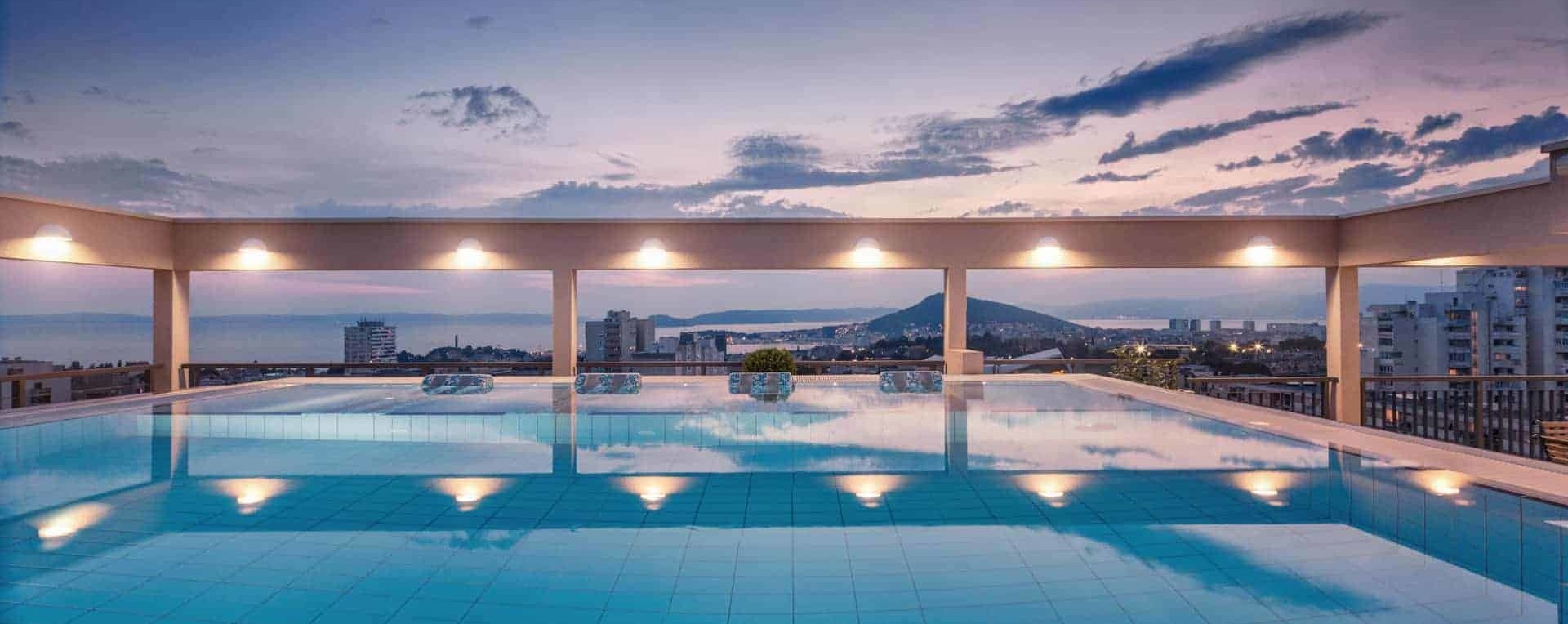 Rooftop pool with a panoramic view on Split Croatia in sunset, crystal clear water, relaxing vacation in Dioklecijan Hotel & Residence