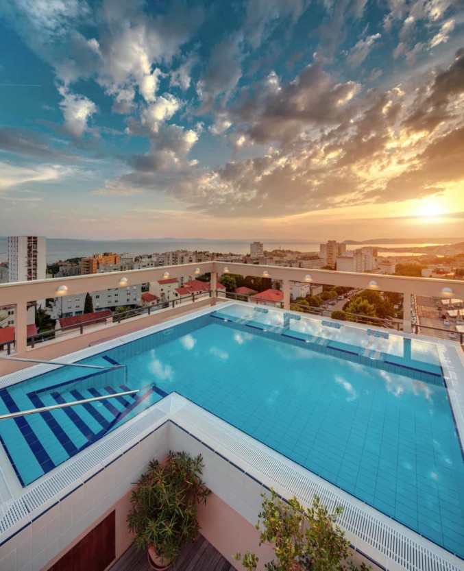 Rooftop pool with a panoramic view on Split Croatia in sunset, crystal clear water, relaxing vacation in Dioklecijan Hotel & Residence